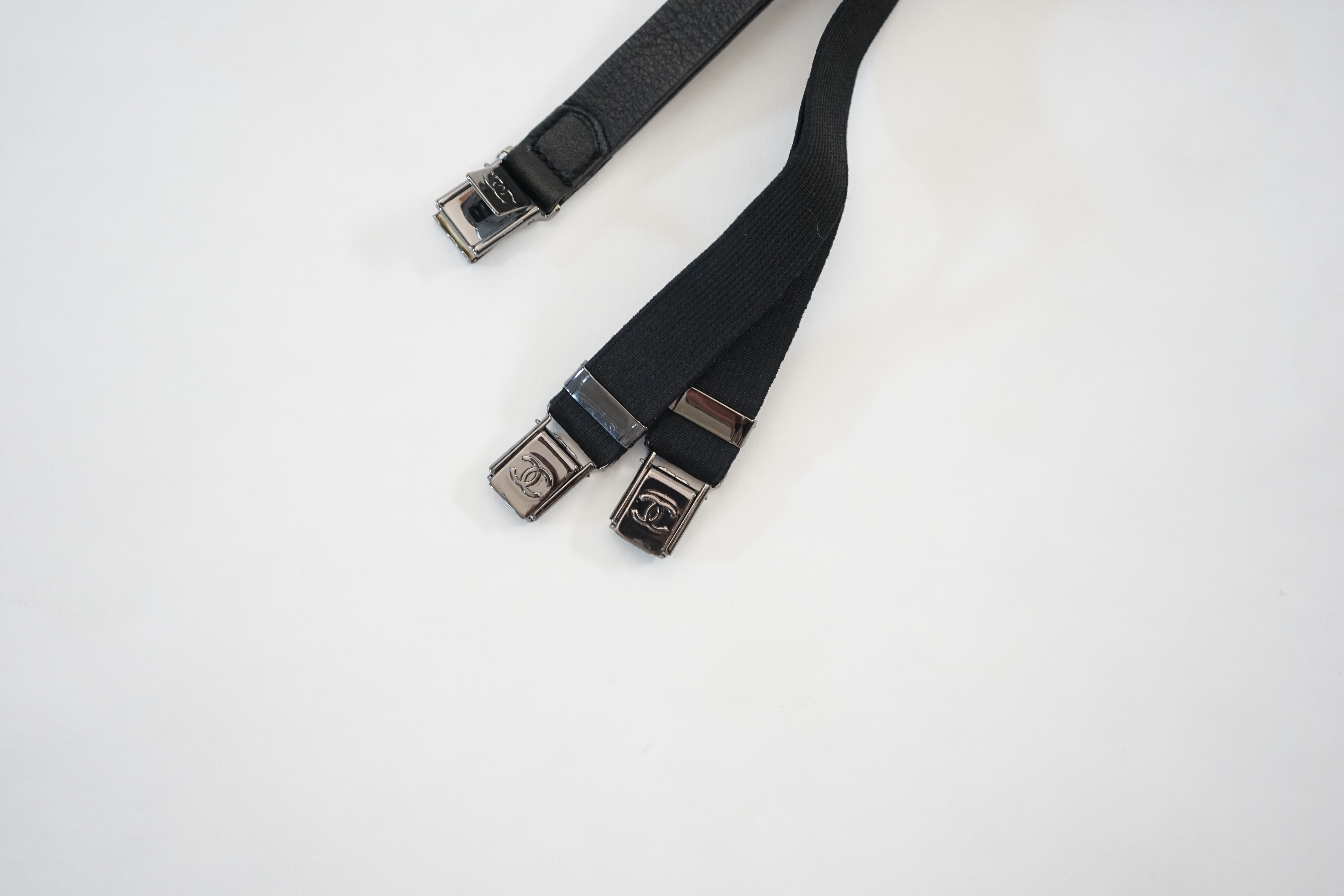 A pair of Chanel black leather one sided braces